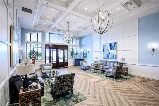 a living room with furniture a large window and a chandelier