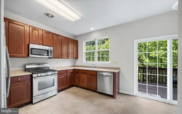 a kitchen with stainless steel appliances granite countertop a refrigerator stove and sink