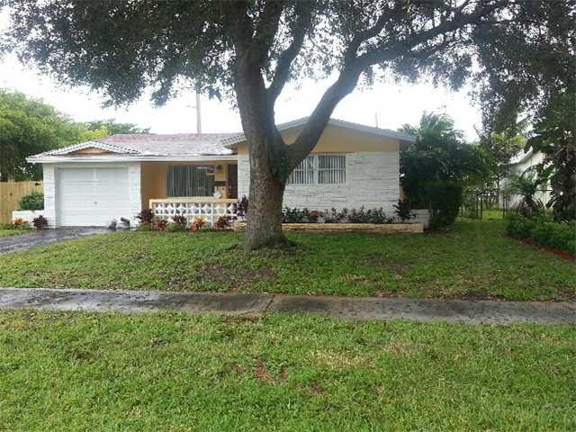 5521 Buchanan Street Hollywood, FL 33021 - Photo 1 of 12 a front view of a house with a yard and garage