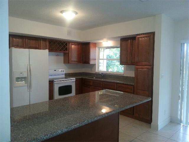 5521 Buchanan Street Hollywood, FL 33021 - Photo 4 of 12 a kitchen with a sink a stove a refrigerator and a window