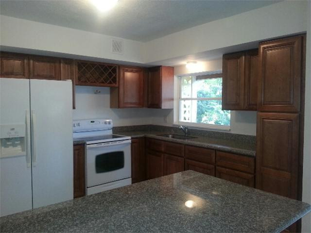 5521 Buchanan Street Hollywood, FL 33021 - Photo 5 of 12 a kitchen with stainless steel appliances granite countertop a stove a refrigerator and a sink