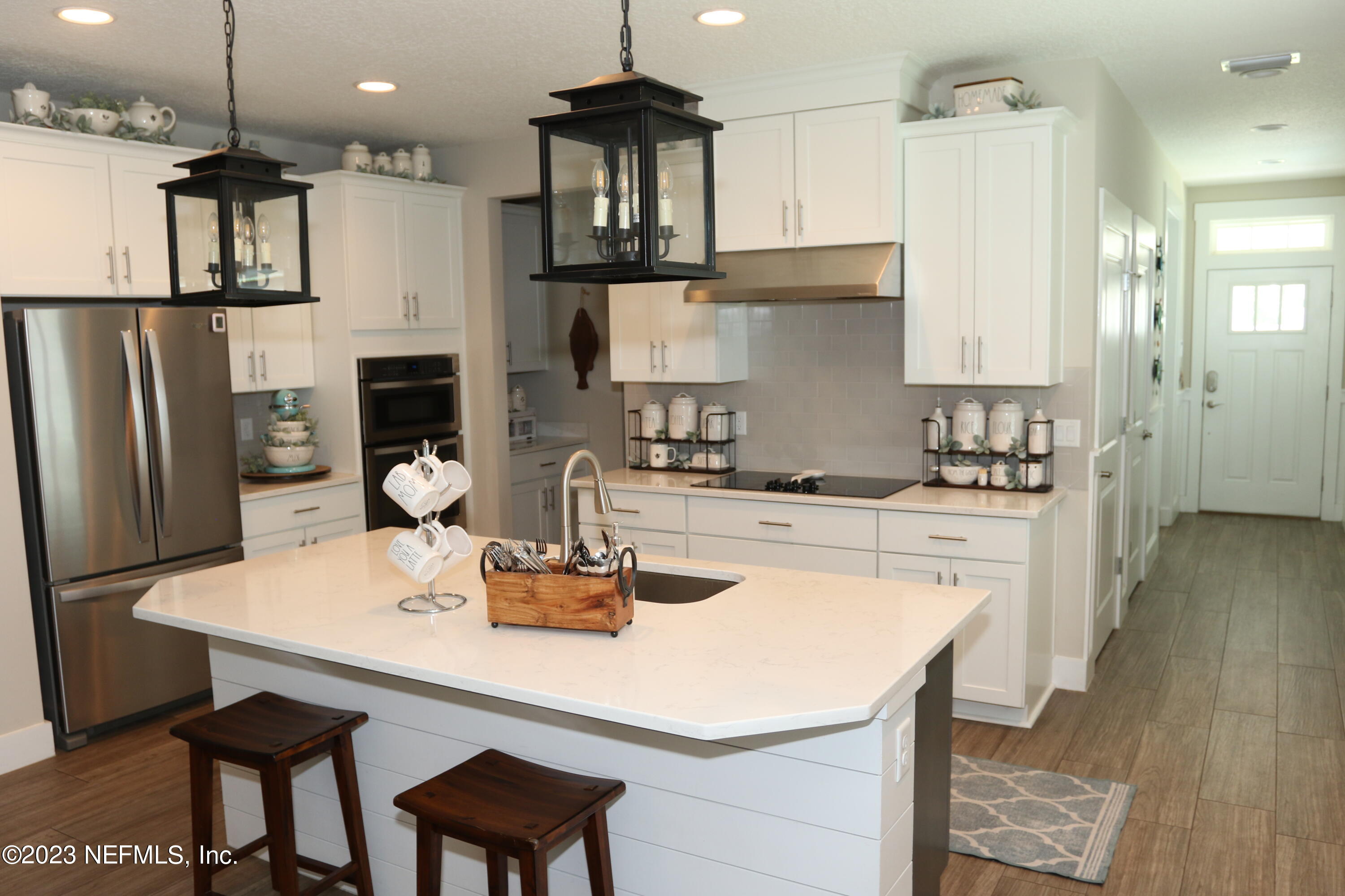 3836 Collins Road Jacksonville, FL 32244 - Photo 23 of 40 a kitchen with stainless steel appliances granite countertop a sink a stove a refrigerator and a dining table with wooden floor