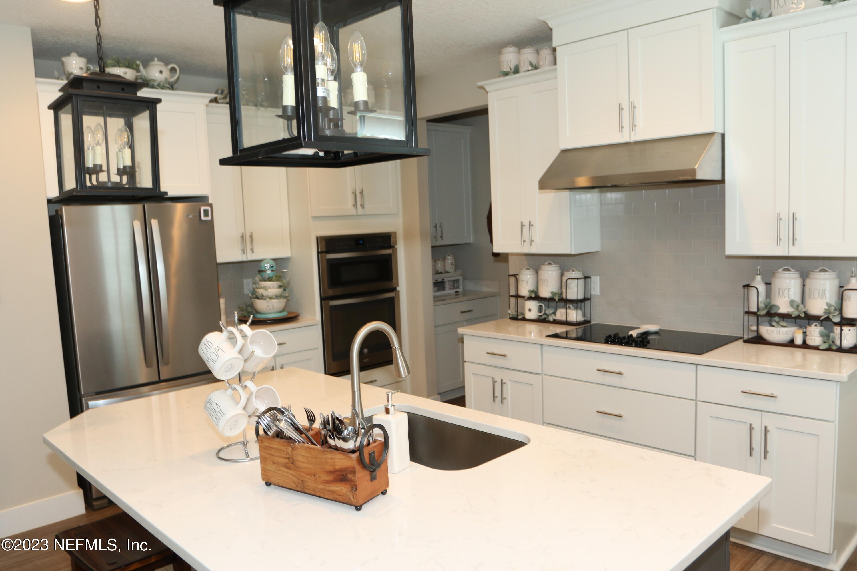 3836 Collins Road Jacksonville, FL 32244 - Photo 28 of 40 a kitchen with stainless steel appliances granite countertop a stove a refrigerator a sink a dining table and chairs with wooden floor