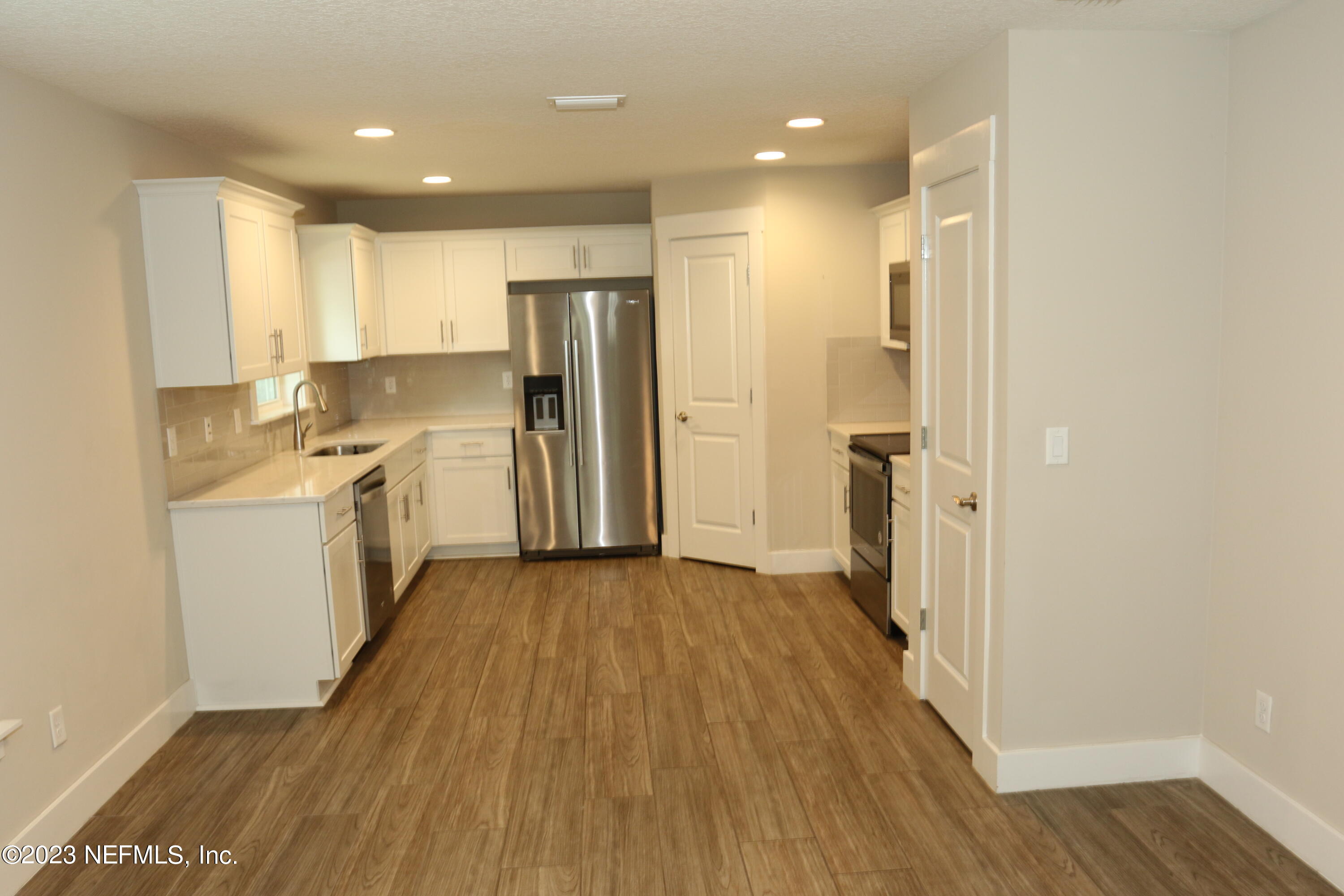 3836 Collins Road Jacksonville, FL 32244 - Photo 37 of 40 a view of a kitchen with wooden floor and electronic appliances