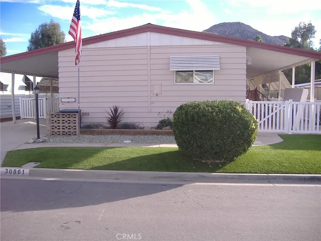 a view of a brick house with a small yard and plants