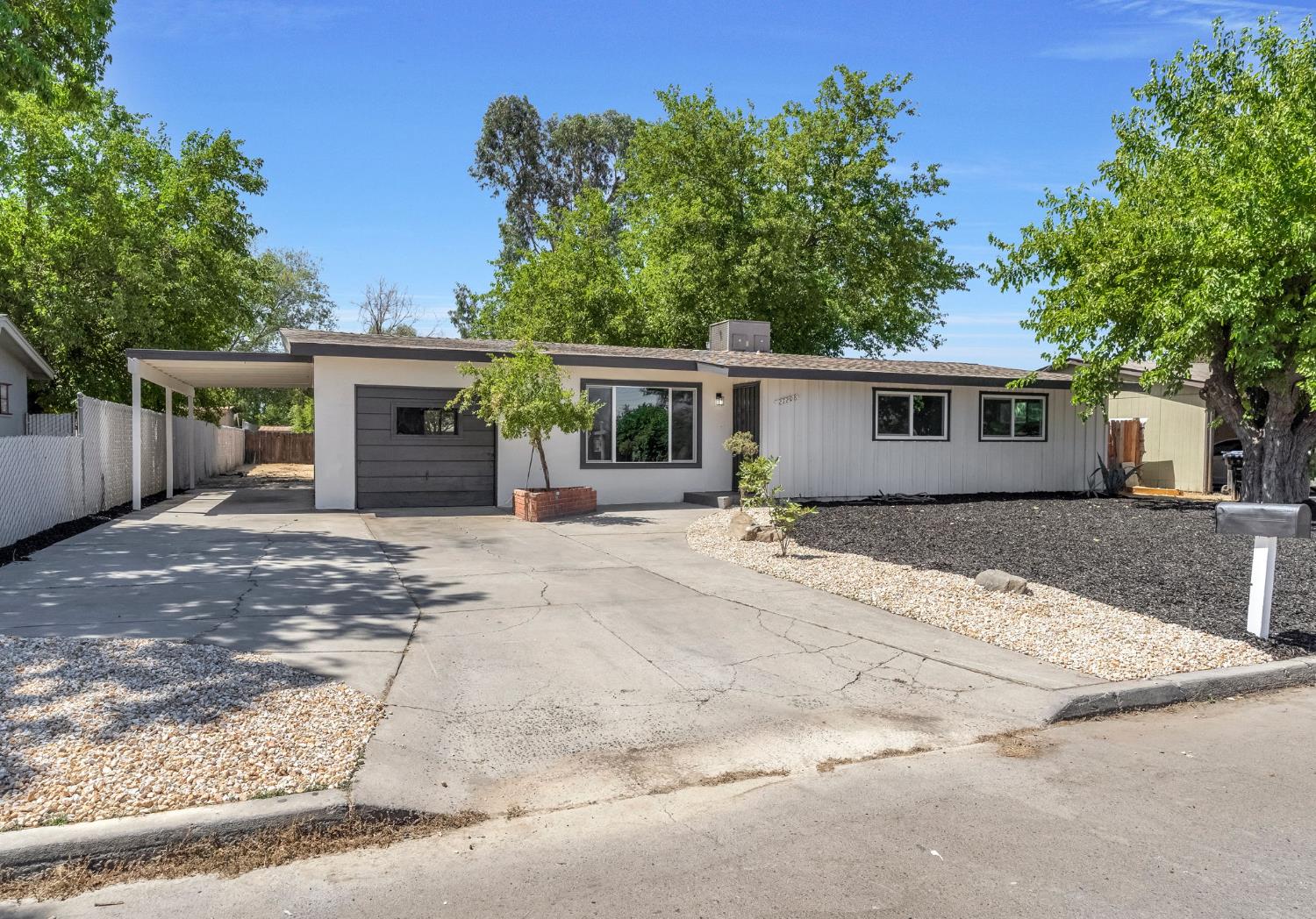 a front view of a house with yard and trees