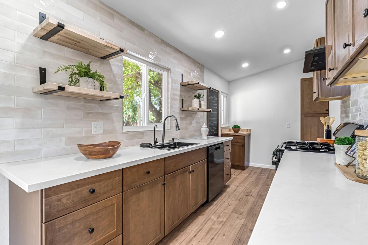 27208 Saunders Road Madera, CA 93637 - Photo 11 of 27 a kitchen with a sink and wooden cabinets