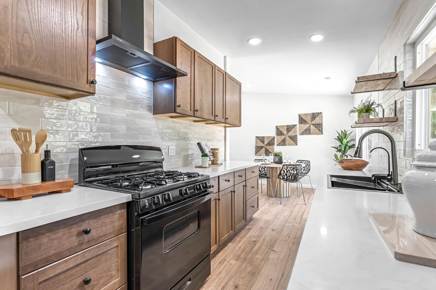 27208 Saunders Road Madera, CA 93637 - Photo 15 of 27 a kitchen with stainless steel appliances granite countertop a stove a sink dishwasher and white cabinets with wooden floor