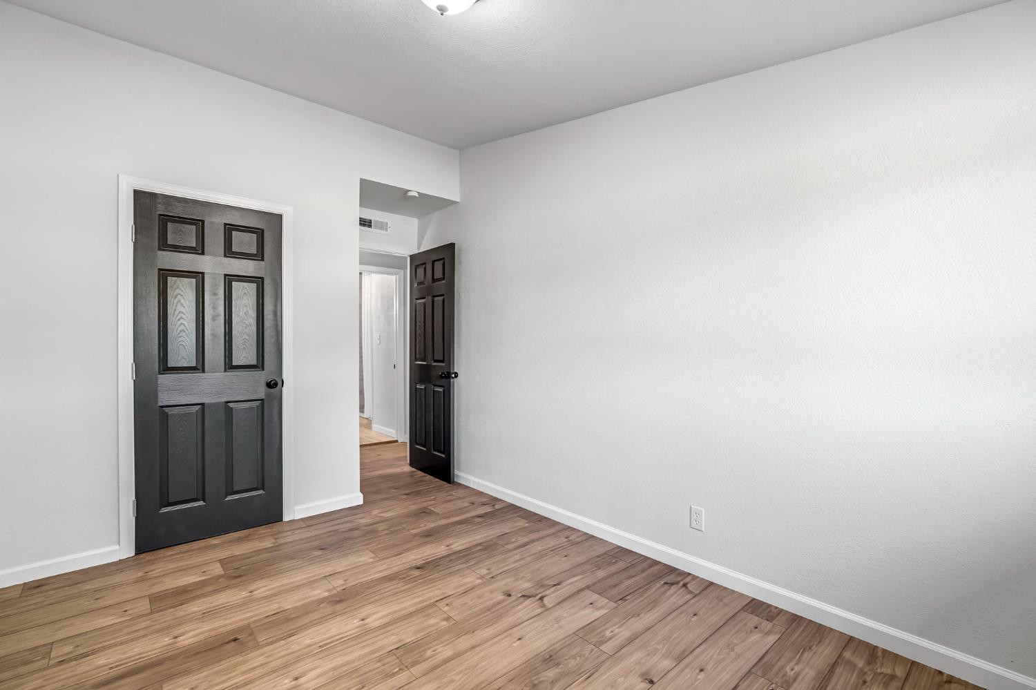 27208 Saunders Road Madera, CA 93637 - Photo 17 of 27 a view of an empty room with wooden floor and closet