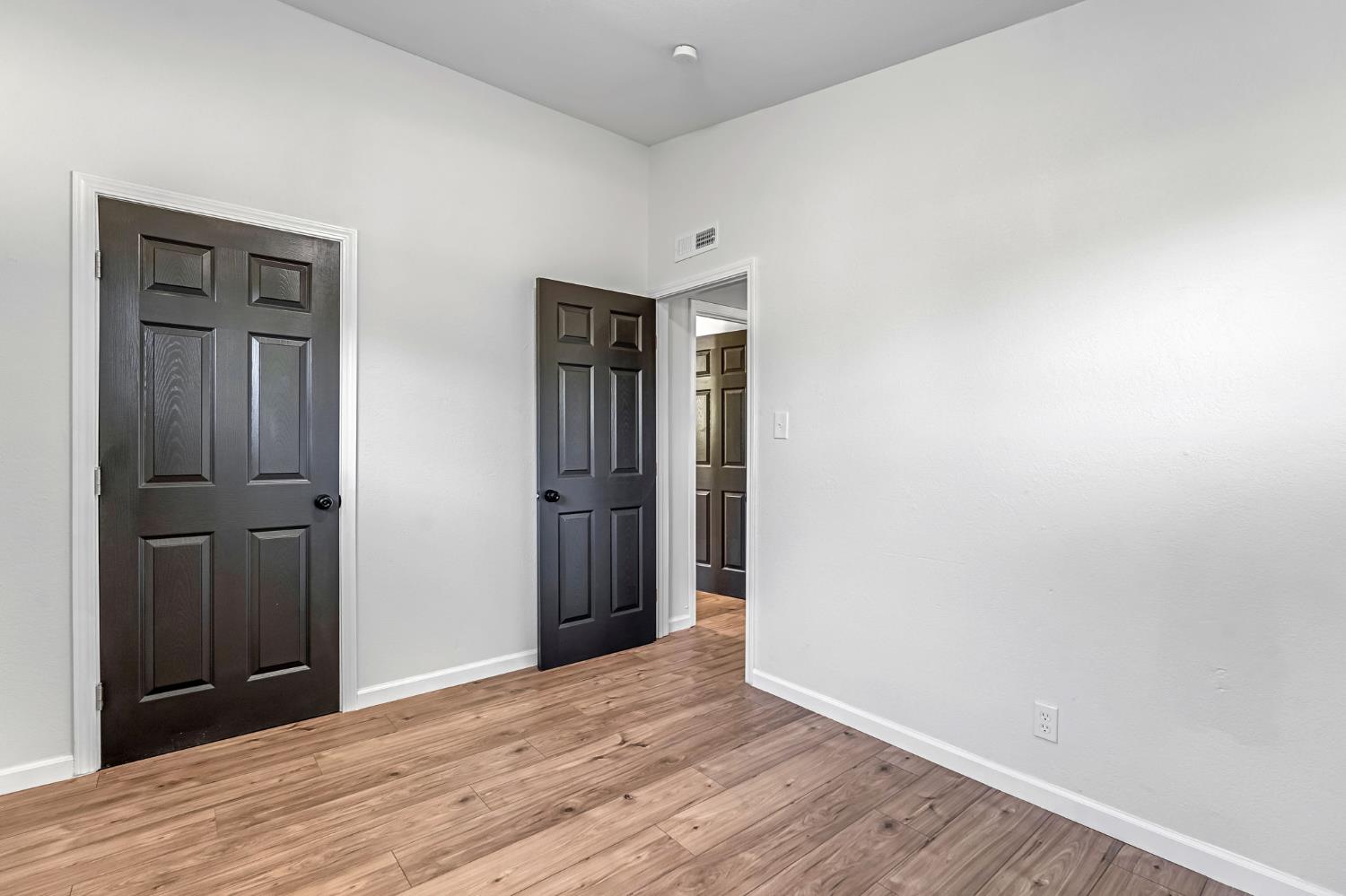 27208 Saunders Road Madera, CA 93637 - Photo 20 of 27 a view of an empty room with closet and wooden floor