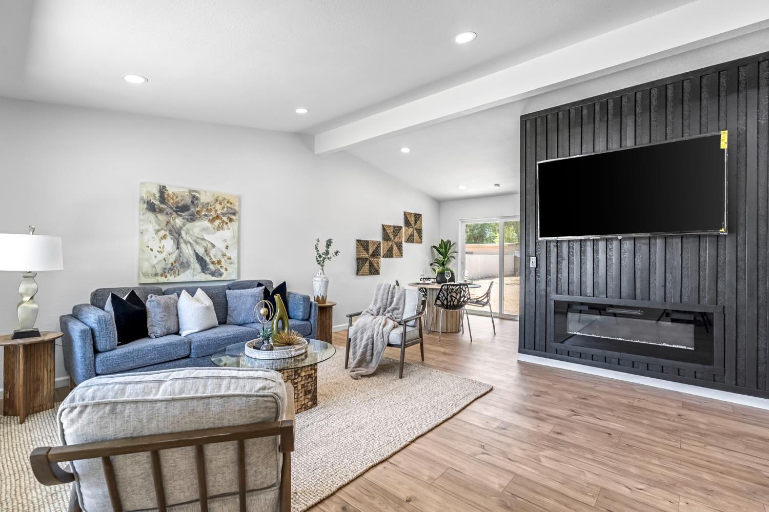 27208 Saunders Road Madera, CA 93637 - Photo 5 of 27 a living room with furniture a flat screen tv and a fireplace