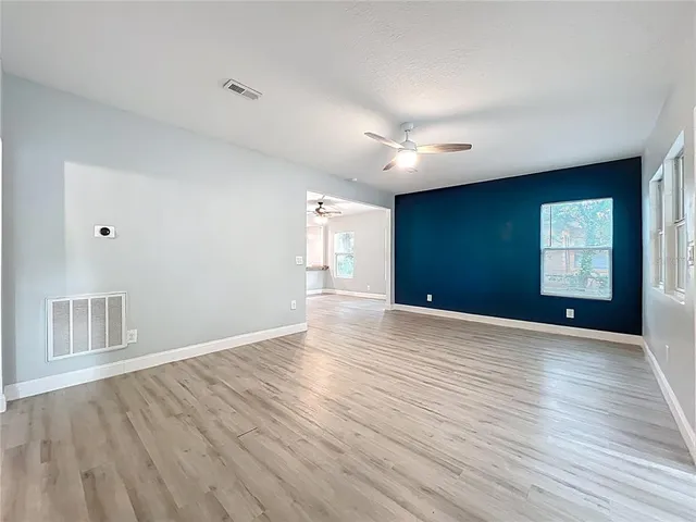 a view of an empty room with wooden floor