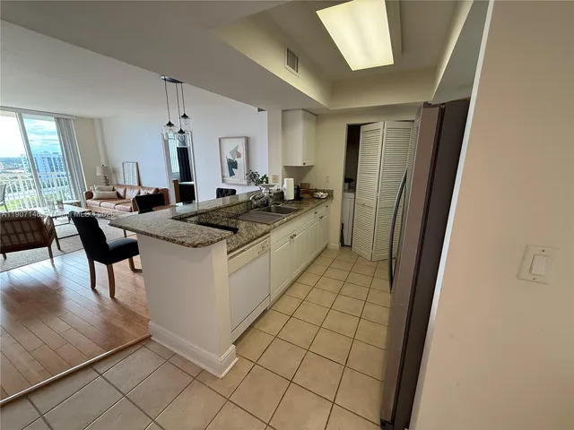 a kitchen with a sink a stove a refrigerator and chairs