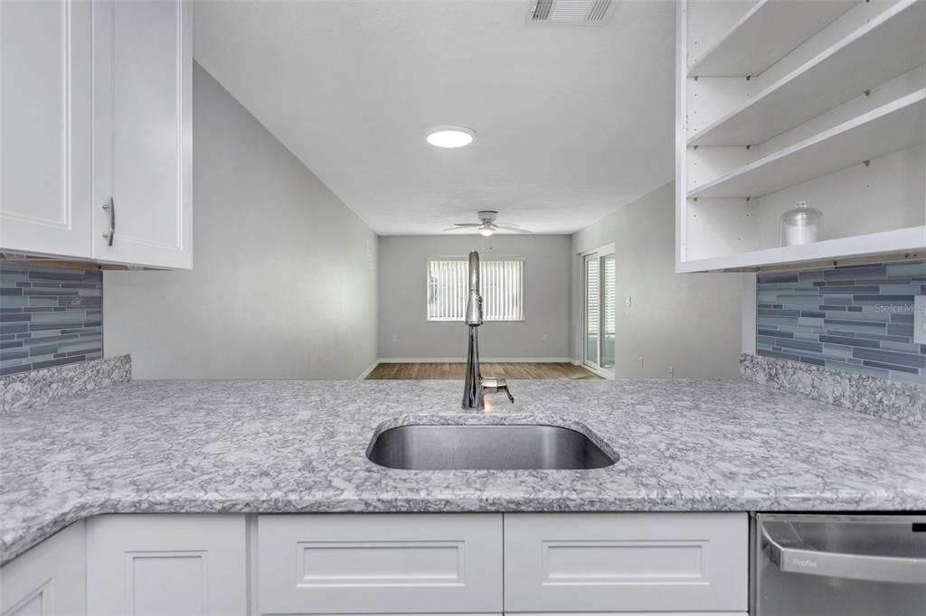 6520 Thicket Trail New Port Richey, FL 34653 - Photo 13 of 43 a kitchen with granite countertop a sink and a granite counter tops