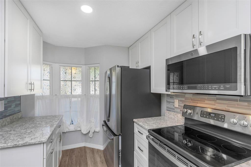 6520 Thicket Trail New Port Richey, FL 34653 - Photo 17 of 43 a kitchen with a stove and a microwave