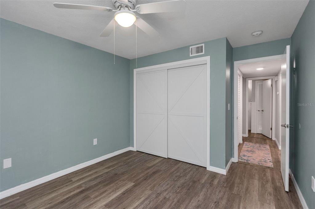 6520 Thicket Trail New Port Richey, FL 34653 - Photo 20 of 43 a view of a room with wooden floor and a ceiling fan