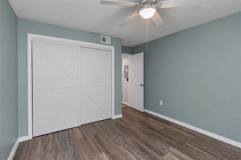 6520 Thicket Trail New Port Richey, FL 34653 - Photo 21 of 43 an empty room with wooden floor and fan