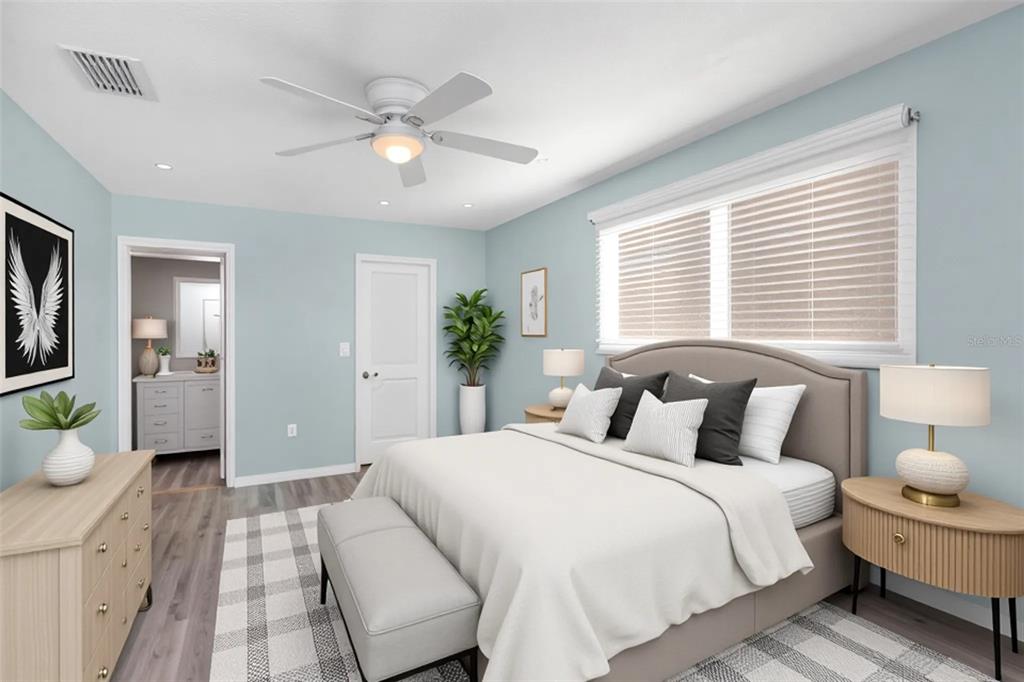 6520 Thicket Trail New Port Richey, FL 34653 - Photo 29 of 43 a bedroom with a large bed and a chandelier fan