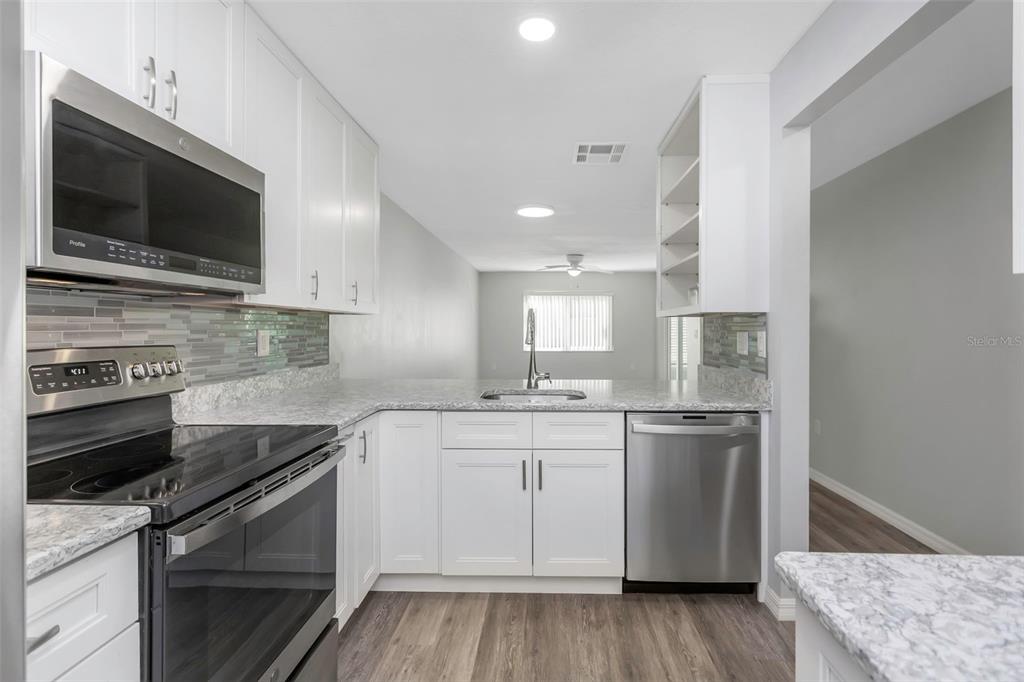 6520 Thicket Trail New Port Richey, FL 34653 - Photo 3 of 43 a kitchen with a sink stove and microwave