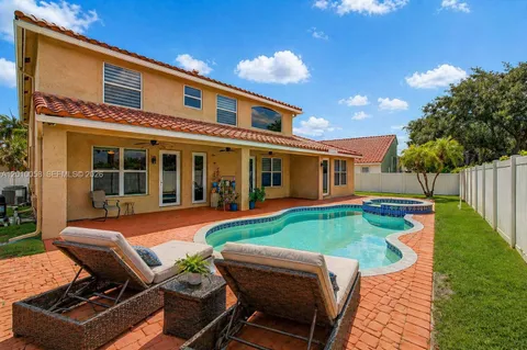 a view of a house with backyard sitting area and swimming pool