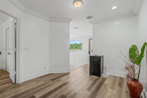 a view of a livingroom with wooden floor and a potted plant