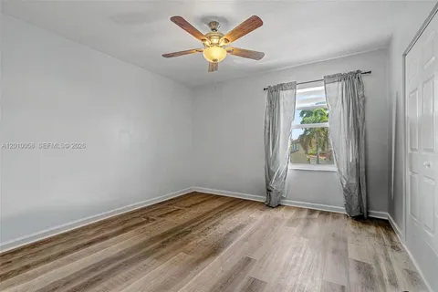 an empty room with wooden floor and window