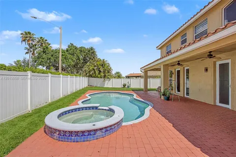 a view of a house with backyard swimming pool and sitting area