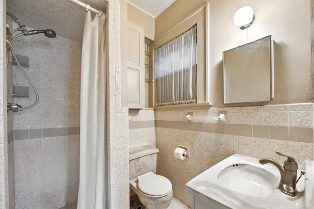 a bathroom with a sink a toilet and a mirror