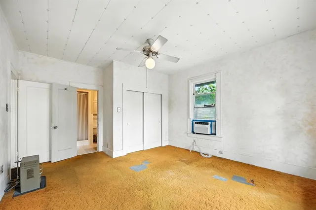 a view of a livingroom with a chandelier fan and windows