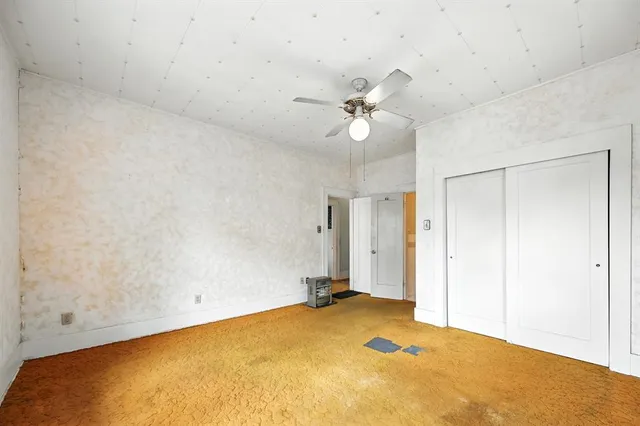 an empty room with a ceiling fan and a window