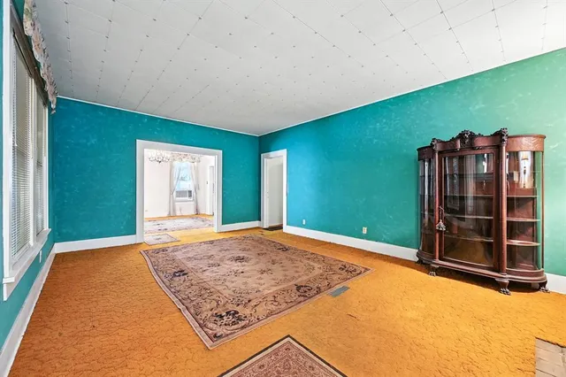 a view of an empty room with wooden floor and closet