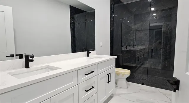 a bathroom with a sink a toilet and shower