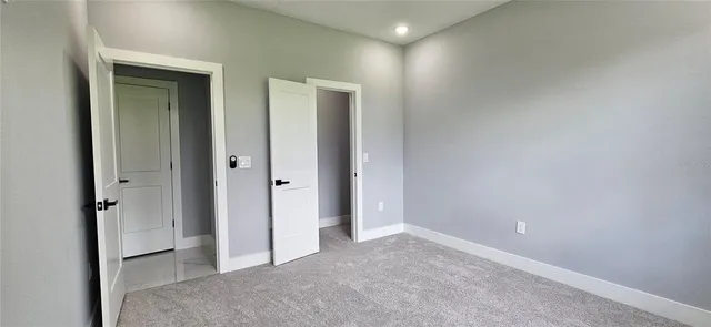 an empty room with closet and mirror