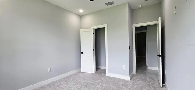 an empty room with closet and wooden door