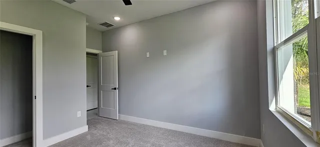 a view of hallway with a window and chandelier