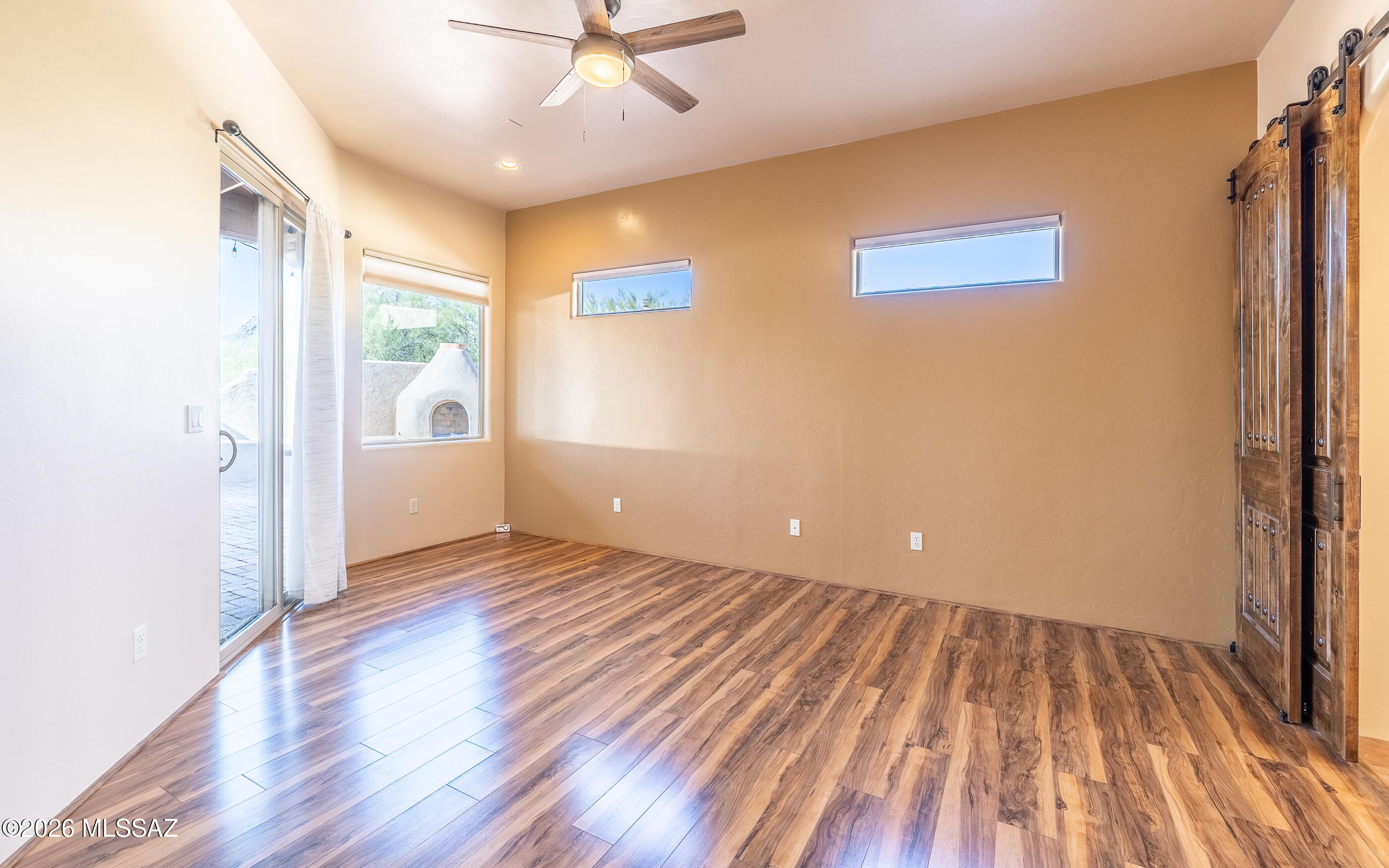 5550 West Open R Place Tucson, AZ 85713 - Photo 23 of 48 This owner's suite features back patio access, a ceiling fan with light fixture keeping the space comfortable, and clerestory windows that allow natural light to filter in!