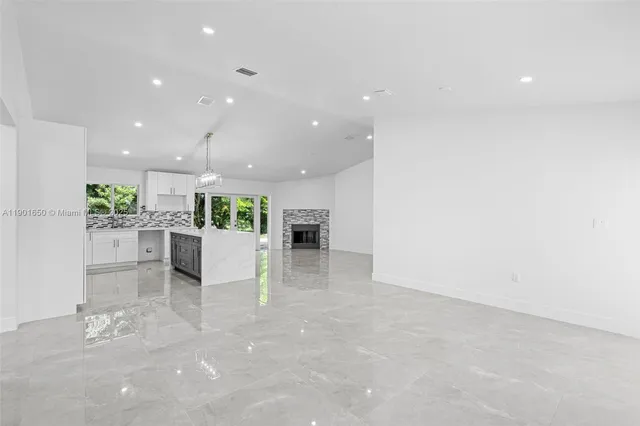 a kitchen with kitchen island granite countertop a sink and cabinets