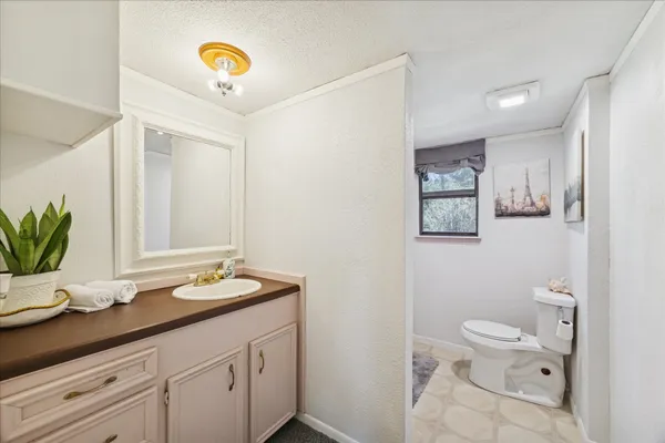 a bathroom with a granite countertop sink a toilet and a mirror