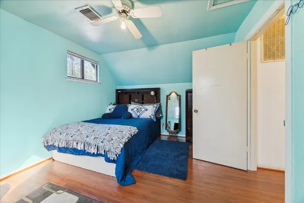 a bedroom with a bed and wooden floor