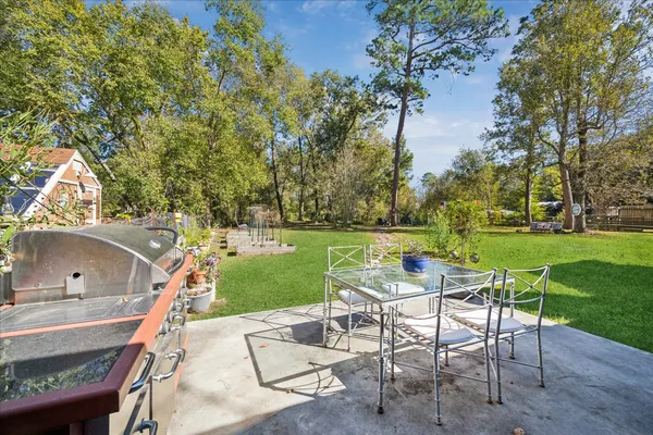 a view of yard with seating space and trees in the background