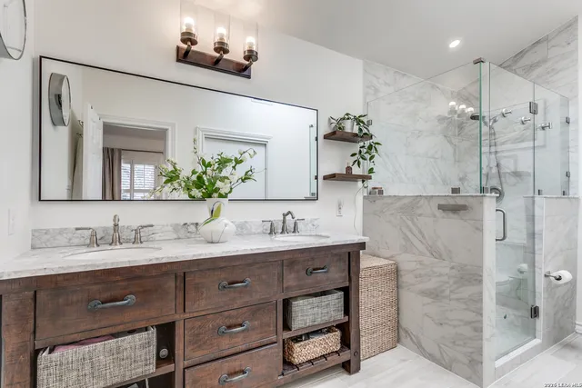 a bathroom with a double vanity sink mirror and shower