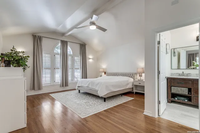 a spacious bedroom with a large bed and a wooden floor