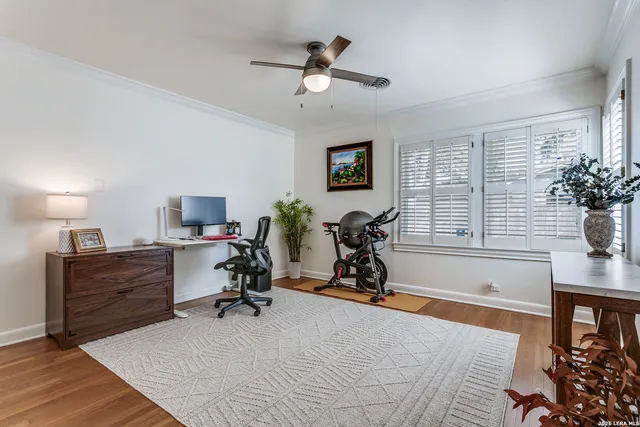 a view of a workspace with furniture and a ceiling fan