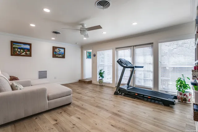 a living room with furniture gym equipment and a potted plant