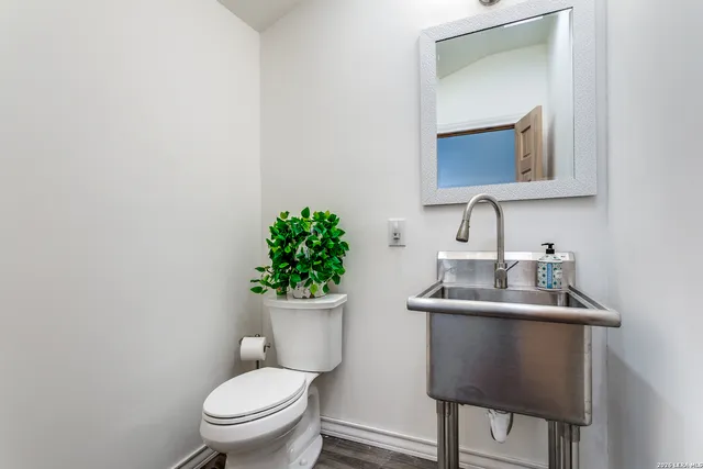 a bathroom with a toilet sink and mirror