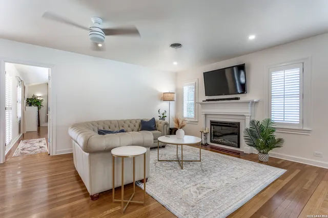 a living room with furniture a flat screen tv and a fireplace
