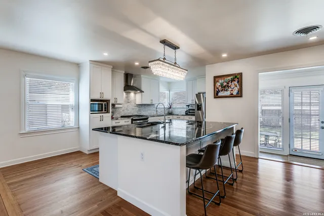 a kitchen with counter top space a sink cabinets and wooden floor