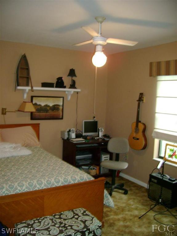8370 Bamboo Road Fort Myers, FL 33967 - Photo 8 of 15 a bedroom with a bed and a chandelier