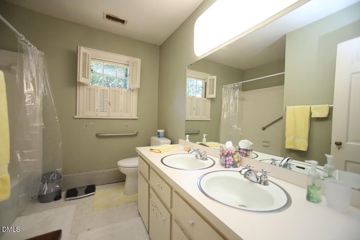 2601 York Road Raleigh, NC 27608 - Photo 12 of 24 a bathroom with a double vanity sink and a mirror