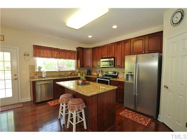 2109 Wide River Drive Raleigh, NC 27614 - Photo 7 of 20 a kitchen with a refrigerator a sink dishwasher with a dining table and wooden floor